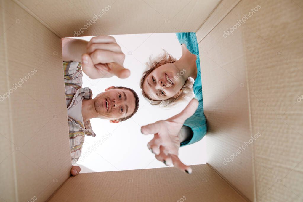Image of man and woman peering into open cardboard box
