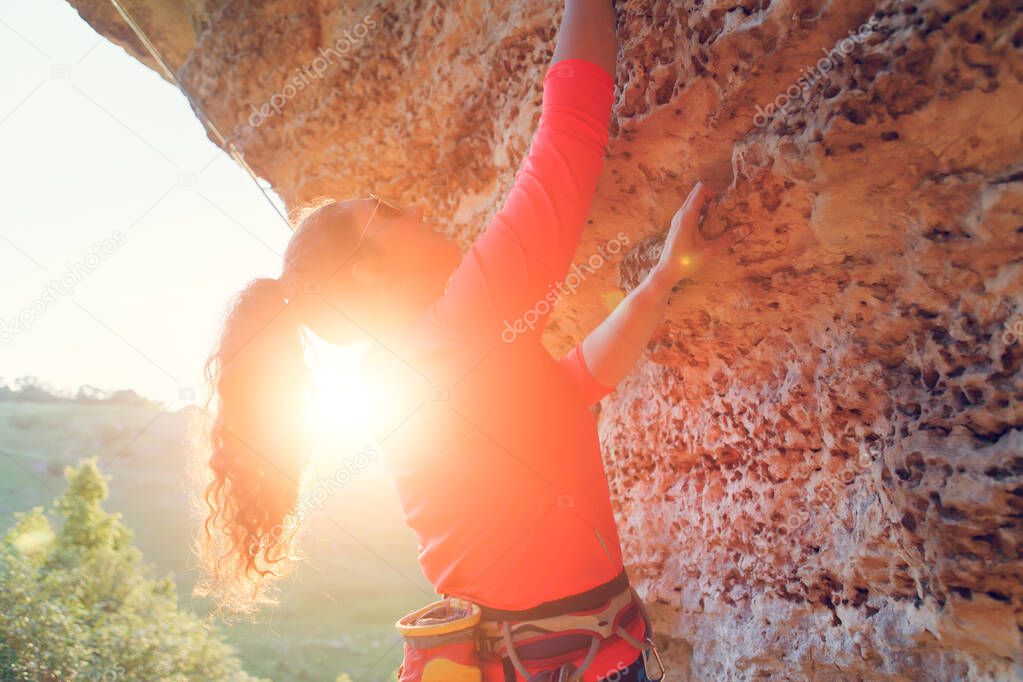Image of young brunette tourist hiking over rock on summer day. Sunlight effect