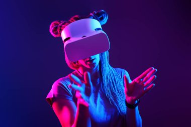Kadın sanal gerçeklik kulaklığı kullanıyor. Neon Light Stüdyo Portresi.