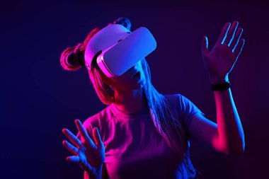 Kadın sanal gerçeklik kulaklığı kullanıyor. Neon Light Stüdyo Portresi.