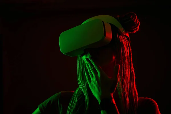 A mulher está usando fones de ouvido de realidade virtual. Retrato de estúdio luz néon. — Fotografia de Stock