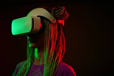 Kadın sanal gerçeklik kulaklığı kullanıyor. Neon Light Stüdyo Portresi.