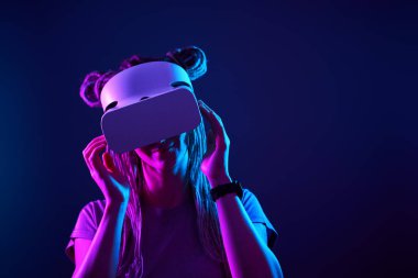 Kadın sanal gerçeklik kulaklığı kullanıyor. Neon Light Stüdyo Portresi.