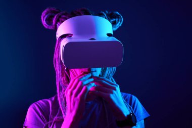 Kadın sanal gerçeklik kulaklığı kullanıyor. Neon Light Stüdyo Portresi.
