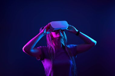 Kadın sanal gerçeklik kulaklığı kullanıyor. Neon Light Stüdyo Portresi.