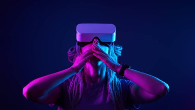Kadın sanal gerçeklik kulaklığı kullanıyor. Neon Light Stüdyo Portresi.