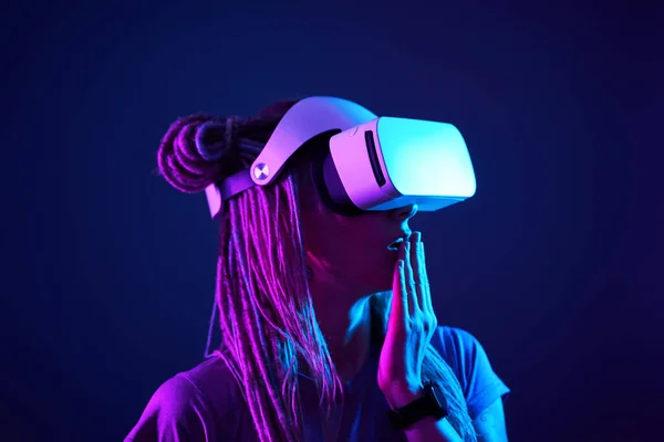 A mulher está usando fones de ouvido de realidade virtual. Retrato de estúdio luz néon. — Fotografia de Stock