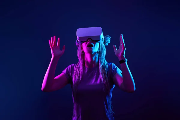 A mulher está usando fones de ouvido de realidade virtual. Retrato de estúdio luz néon. — Fotografia de Stock