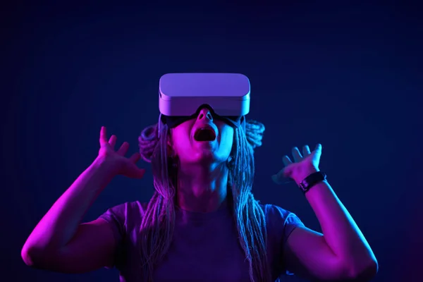 Vrouw gebruikt virtual reality headset. Neon licht studio portret. — Stockfoto