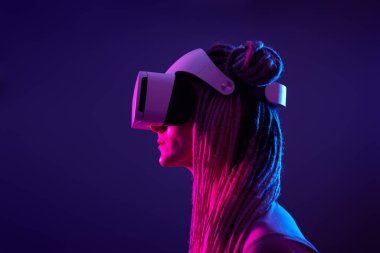Kadın sanal gerçeklik kulaklığı kullanıyor. Neon Light Stüdyo Portresi.