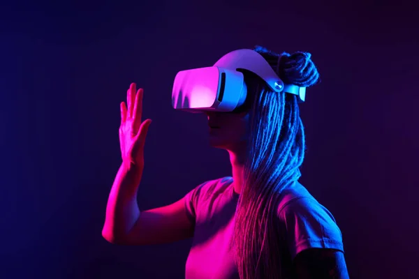 Vrouw gebruikt virtual reality headset. Neon licht studio portret. — Stockfoto