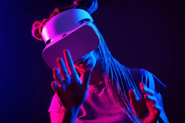 Donna sta usando cuffie realtà virtuale. Neon luce studio ritratto. — Foto Stock