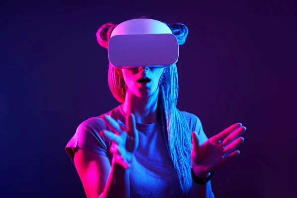 A mulher está usando fones de ouvido de realidade virtual. Retrato de estúdio luz néon. — Fotografia de Stock