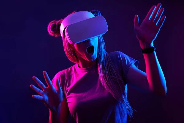 La femme utilise un casque de réalité virtuelle. Portrait studio lumière néon. — Photo