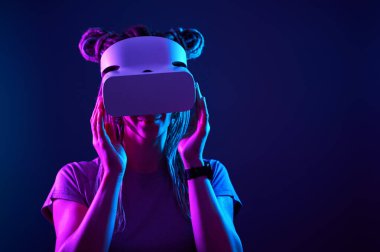 Kadın sanal gerçeklik kulaklığı kullanıyor. Neon Light Stüdyo Portresi.