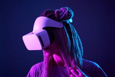 Kadın sanal gerçeklik kulaklığı kullanıyor. Neon Light Stüdyo Portresi.