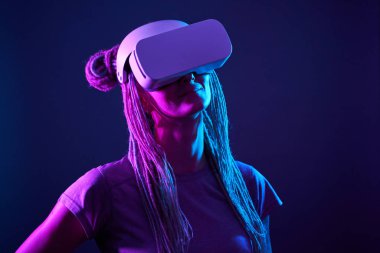 Kadın sanal gerçeklik kulaklığı kullanıyor. Neon Light Stüdyo Portresi.