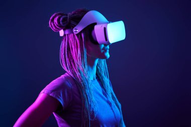 Kadın sanal gerçeklik kulaklığı kullanıyor. Neon Light Stüdyo Portresi.