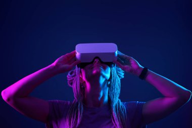 Kadın sanal gerçeklik kulaklığı kullanıyor. Neon Light Stüdyo Portresi.