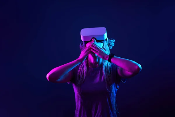 Donna sta usando cuffie realtà virtuale. Neon luce studio ritratto. — Foto Stock