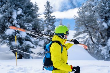 Omzunda kayak olan kasklı bir adamın portresi.