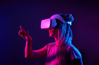 Kadın sanal gerçeklik kulaklığı kullanıyor. Neon Light Stüdyo Portresi.