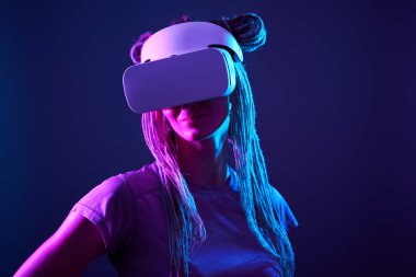 Kadın sanal gerçeklik kulaklığı kullanıyor. Neon Light Stüdyo Portresi.