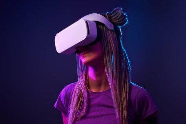 Kadın sanal gerçeklik kulaklığı kullanıyor. Neon Light Stüdyo Portresi.