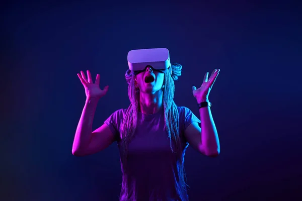 Vrouw gebruikt virtual reality headset. Neon licht studio portret. — Stockfoto