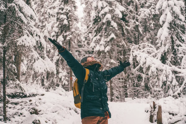 Foto de homem com as mãos para cima para caminhar na floresta de inverno . — Fotografia de Stock