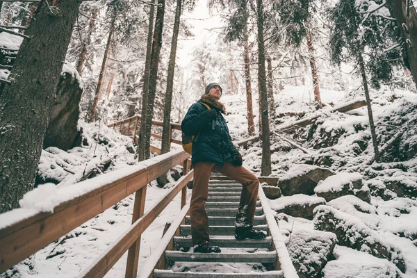 Bild av människan i vinterskogen på träbro . — Stockfoto