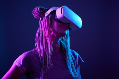 Kadın sanal gerçeklik kulaklığı kullanıyor. Neon Light Stüdyo Portresi.