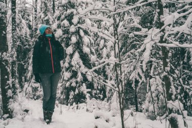 Photo of tourist woman walking in winter forest