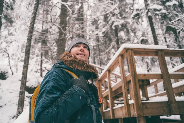 Foto do homem na floresta de inverno na ponte de madeira . — Fotografia de Stock