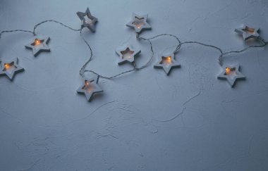 Boş mavi masada yanan Noel çelengi