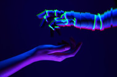 Kadın ve robotlar insanlar ve teknoloji arasındaki bağlantının sembolü olarak el ele tutuşuyorlar. Neon renkleri.