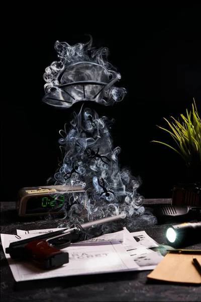 Pistola na mesa com jornal, fumaça no fundo preto — Fotografia de Stock