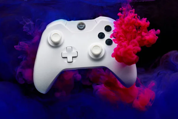 Joystick jogo com fumaça rosa e roxa no fundo preto em branco — Fotografia de Stock