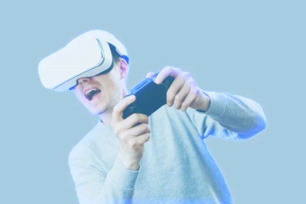 Hombre con auriculares de realidad virtual está jugando juego. Imagen con efecto holograma . —  Fotos de Stock
