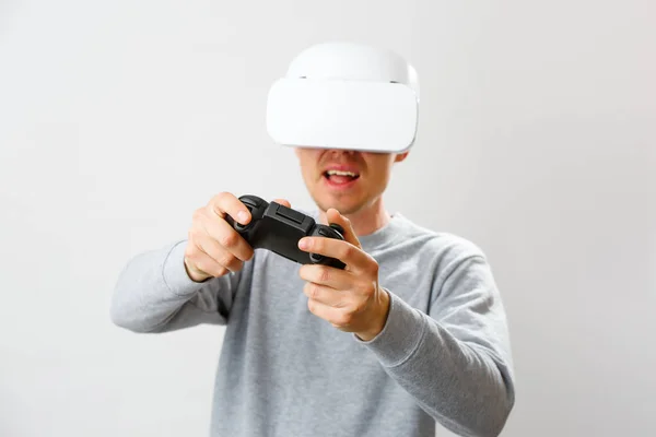 Člověk s náhlavní soupravou s virtuální realitou hraje hru. — Stock fotografie