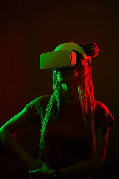 La femme utilise un casque de réalité virtuelle. Portrait studio lumière néon. — Photo