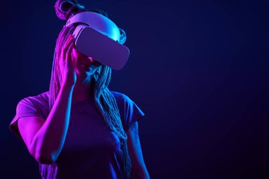 Kadın sanal gerçeklik kulaklığı kullanıyor. Neon Light Stüdyo Portresi.