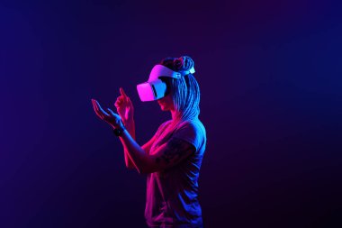 Kadın sanal gerçeklik kulaklığı kullanıyor. Neon Light Stüdyo Portresi.