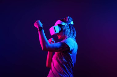 Kadın sanal gerçeklik kulaklığı kullanıyor. Neon Light Stüdyo Portresi.