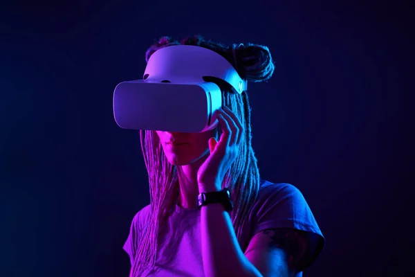 A mulher está usando fones de ouvido de realidade virtual. Retrato de estúdio luz néon. — Fotografia de Stock