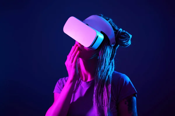 A mulher está usando fones de ouvido de realidade virtual. Retrato de estúdio luz néon. — Fotografia de Stock