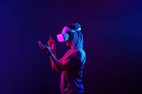 Woman is using virtual reality headset. Neon light studio portrait. — Stock Photo, Image