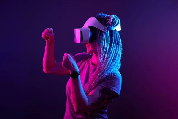 La femme utilise un casque de réalité virtuelle. Portrait studio lumière néon. — Photo