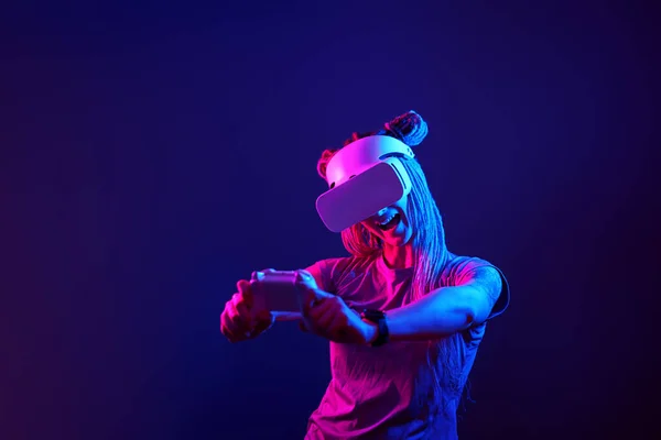 Donna sta usando cuffie realtà virtuale. Neon luce studio ritratto. — Foto Stock