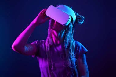 Kadın sanal gerçeklik kulaklığı kullanıyor. Neon Light Stüdyo Portresi.